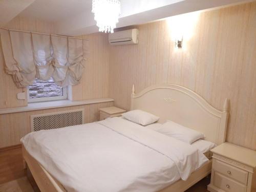 a bedroom with a white bed and a window at Sofiivs'ka apartments in Kyiv