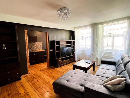 a living room with a couch and a tv at Dome square apartment, Old Town in Riga