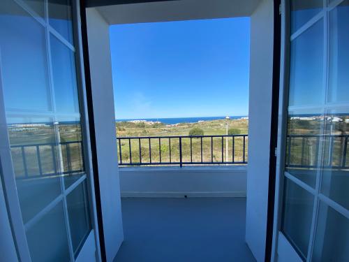 a room with a view of a balcony at Ericeira Sand Beach F4 in Ericeira