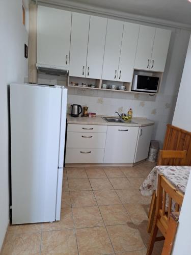a kitchen with white cabinets and a white refrigerator at Apartmán U Rogala in Děčín