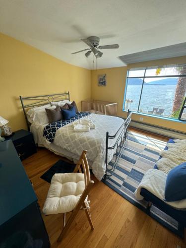 um quarto com uma cama, uma cadeira e uma janela em Pacific Gem em West Vancouver