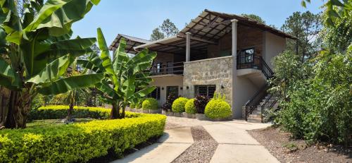 a house with a garden in front of it at Tinyhouses and Tropical Gardens in Zambrano