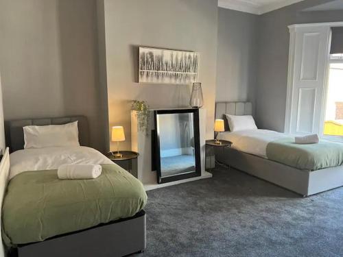 Westoe的住宿－South Shields Stays，一间卧室配有两张床和镜子