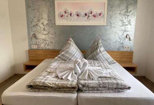 a bed with two pillows with a bow on it at Pension Seehund in Norden