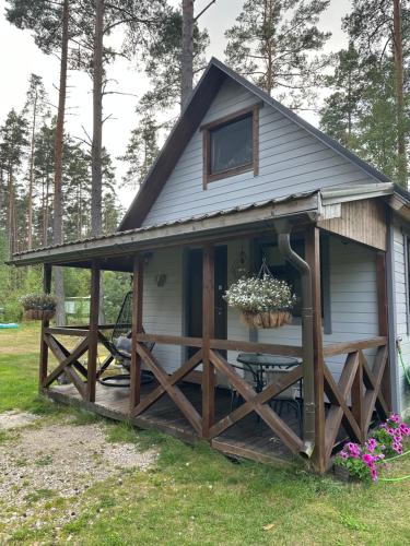 a shed with a porch and a fence at Kurumajake Peipsi järv in Kuru