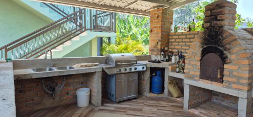 an outdoor kitchen with a brick oven and an outdoor grill at Tinyhouses and Tropical Gardens in Zambrano