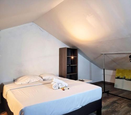 a bedroom with a bed with a white bedspread at T2 Le Corail Duplex 45 m2 - 10 min de l'aéroport in Sainte-Clotilde