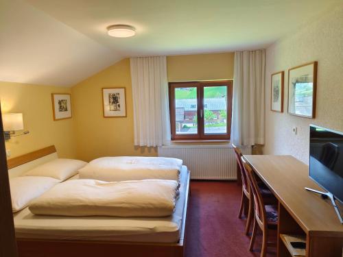 ショペルナウにあるPension Zitaのベッドとデスクが備わるホテルルームです。