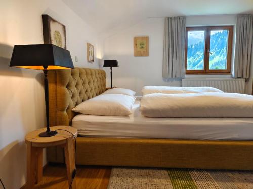 1 dormitorio con 2 camas y una lámpara en una mesa en Pension Zita, en Schoppernau