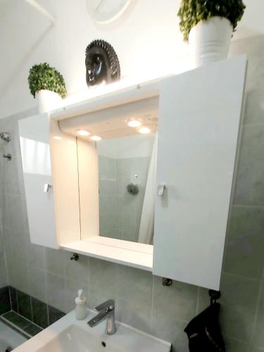 a bathroom with a sink and a mirror at MIDI ROOM terrace wifi carparking in Siófok