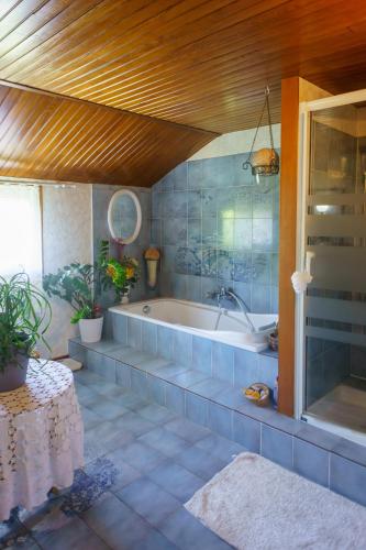 La grande salle de bains est pourvue d'une baignoire et d'une table. dans l'établissement Chez Pepette et Serge, à Montdragon