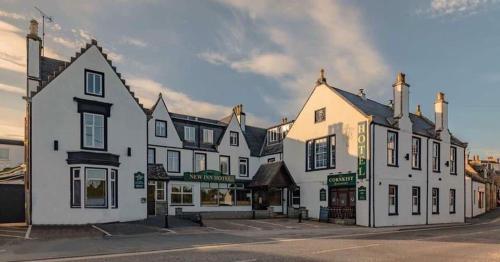a row of white buildings on a street at New Inn Hotel in Ellon