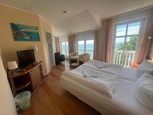 a hotel room with a bed and a television at Fährblick - Pension direkt am Wasser in Sassnitz