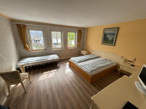 Hotel Seeschau في رايشناو: غرفة نوم بسريرين وطاولة وكراسي
