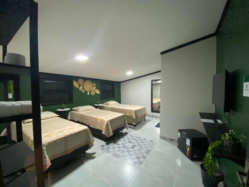 1 dormitorio con 2 camas y TV de pantalla plana en Pousada Point en Aracati