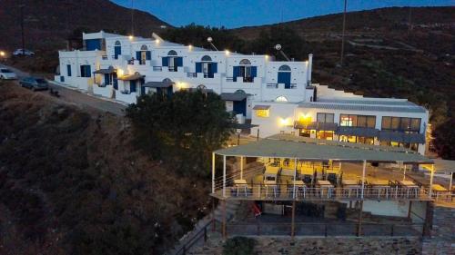 a large white building on top of a hill at Kohili Kolibithra in Tinos in Kollimpithra