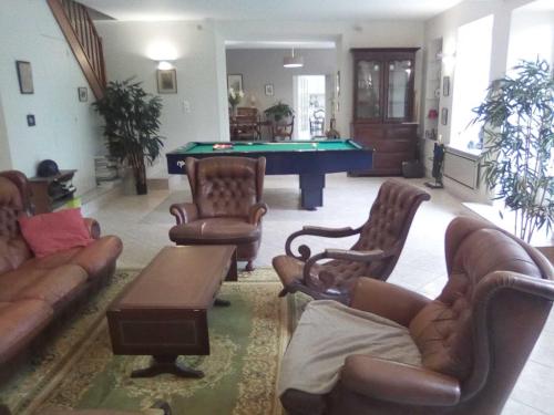 a living room with couches and a pool table at Maison de village in Pévy