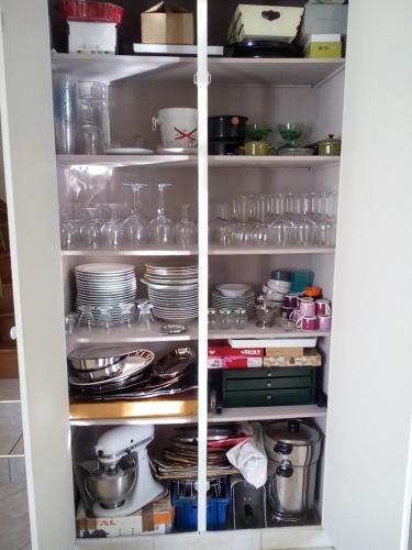 a pantry with plates and dishes on shelves at Maison de village in Pévy