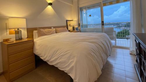 sypialnia z dużym łóżkiem i dużym oknem w obiekcie Cap Salou Mar w Salou
