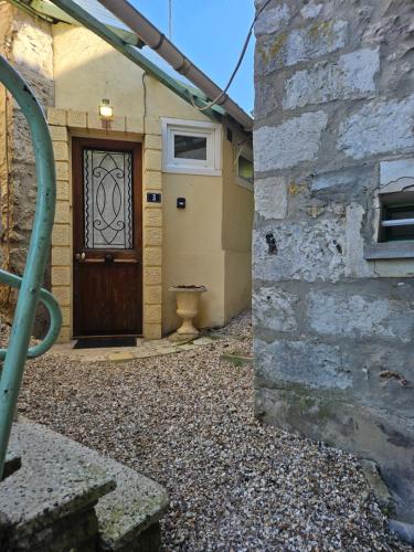 a door to a house with a stone wall at La Petite Maison Romantique Giverny 5km in Bennecourt