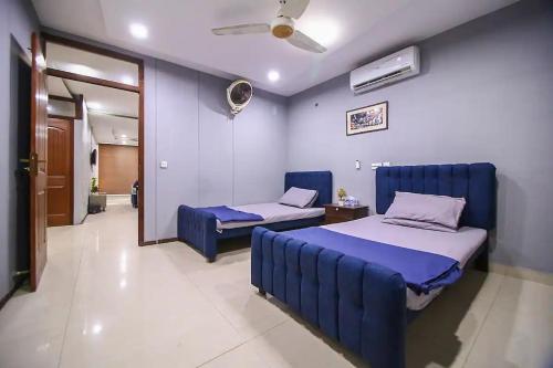 1 dormitorio con 2 camas y pared azul en Hotel and apartments inn en Lahore