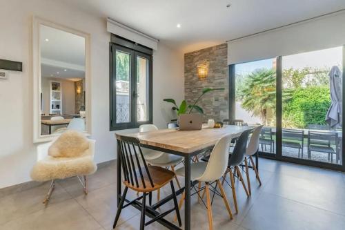 une salle à manger avec une table et des chaises en bois dans l'établissement JO 2024 - Maison d'architecte avec jardin, à Villeneuve-la-Garenne