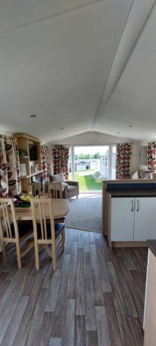 a room with a table and chairs and a kitchen at Holiday Home - St Austell in St Austell