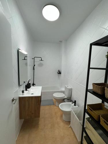 a white bathroom with a toilet and a sink at Apartamentos El Llano Málaga 7 in Sorbas