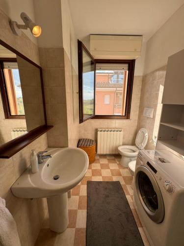 a bathroom with a sink and a washing machine at Appartamento Silvia in Santa Veneranda