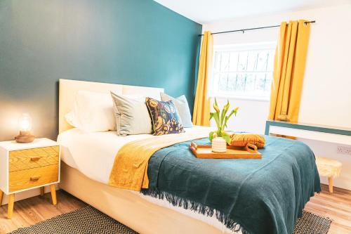 Tunstall House في تشلتنهام: غرفة نوم بسرير مع جدار ازرق