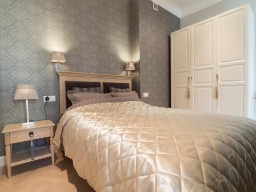 a bedroom with a large bed and a table with a night stand at Best Apartments Św. Antoniego in Wrocław