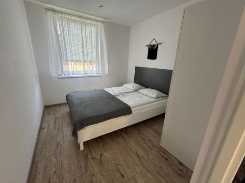 a bedroom with a bed and a window at Apartamenty Jeżynowa 20 in Rowy