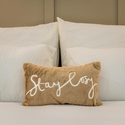 a pillow with stay written on it sitting on a bed at Paris House - New one bedroom apartment in Żejtun