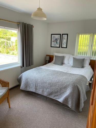 um quarto com uma cama grande e uma janela em Leylands Annexe em East Harptree