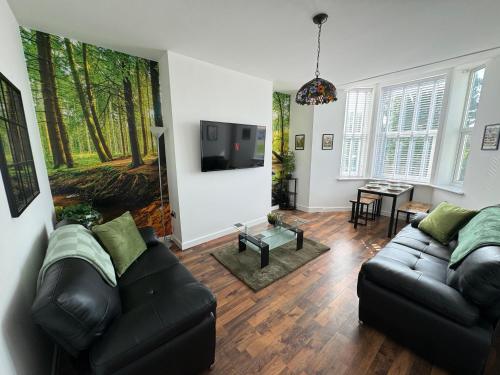a living room with a couch and a tv at Spanish City View 3 Stunning sea front apartment Free onsite parking in Whitley Bay