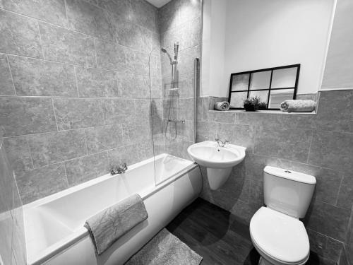 a bathroom with a sink and a toilet and a bath tub at Spanish City View 3 Stunning sea front apartment Free onsite parking in Whitley Bay