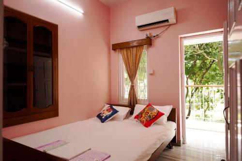 a small bedroom with a bed and a window at The Nerd Nest Kolkata in Kolkata