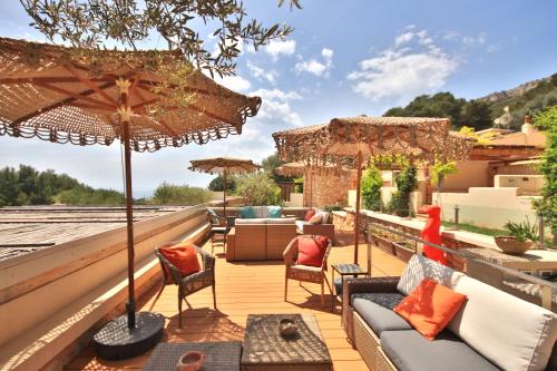 un patio con muebles y una sombrilla en el techo en Dolcevita Egadi Eco Resort by KlabHouse, en Levanzo