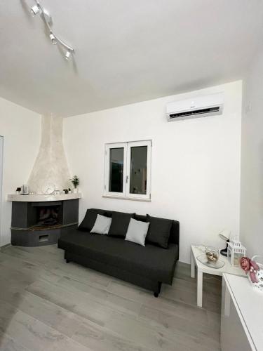 uma sala de estar com um sofá preto e uma lareira em Villa Rita em Corato