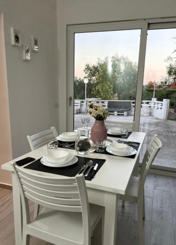 uma mesa branca com cadeiras e um vaso com flores em Villa Rita em Corato