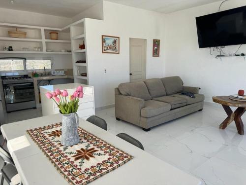 a living room with a couch and a table with flowers at Casa sierra de la Laguna in Salalito