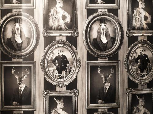 a group of framed pictures of people and animals on a wall at Best Apartments Św. Antoniego in Wrocław