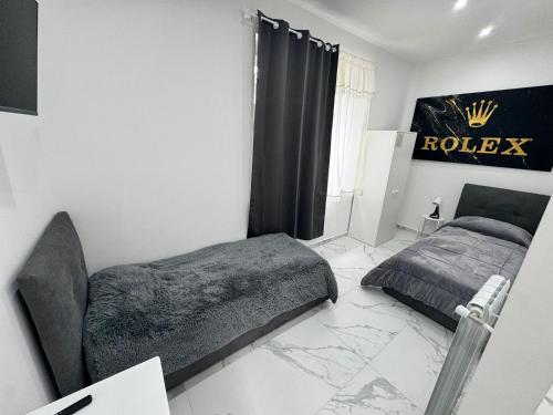 1 dormitorio con 2 camas y un cartel de Rolex en la pared en Villa Life en San Donato Milanese
