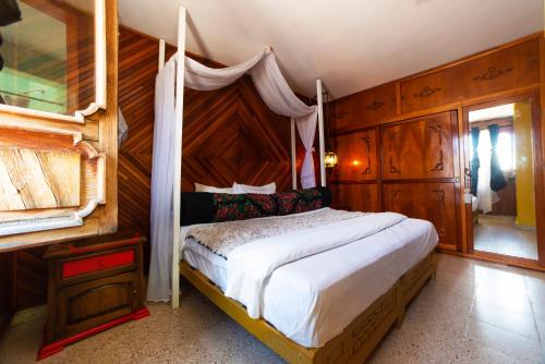 1 dormitorio con 1 cama grande con dosel en Kaza Muta en San Cristóbal de Las Casas