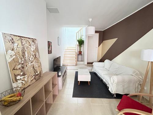 - un salon avec un canapé blanc et un escalier dans l'établissement Maison 2chambres 3lits, à Nizas