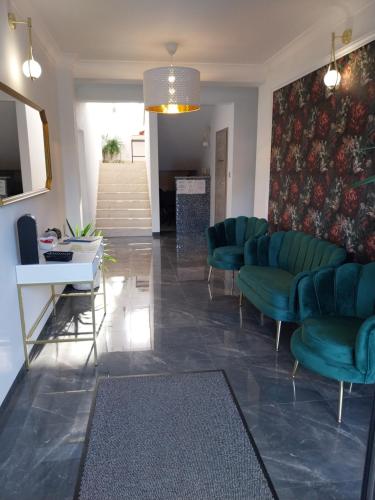 a waiting room with green chairs and a table at VILLA EDEN USTKA wypoczynek dla dorosłych in Ustka
