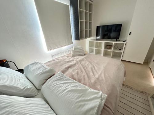 a bedroom with two beds and a flat screen tv at Villa Anastazja in Vendelsö