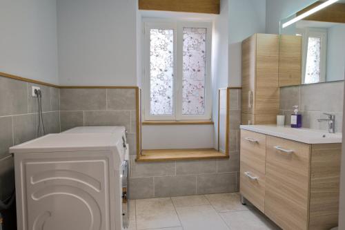 a bathroom with a toilet and a sink and a window at Le gîte du centre, parking avec recharge pour véhicule électrique in Avrecourt
