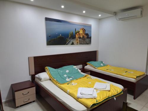 2 Betten in einem Zimmer mit einem Bild an der Wand in der Unterkunft Apartment Delfina in Ohrid
