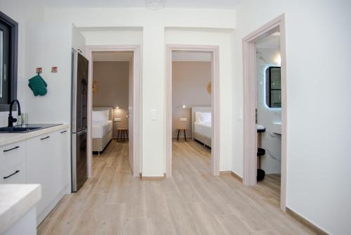 a kitchen with white walls and a wooden floor at Aella Apartment in Skala Kefalonias